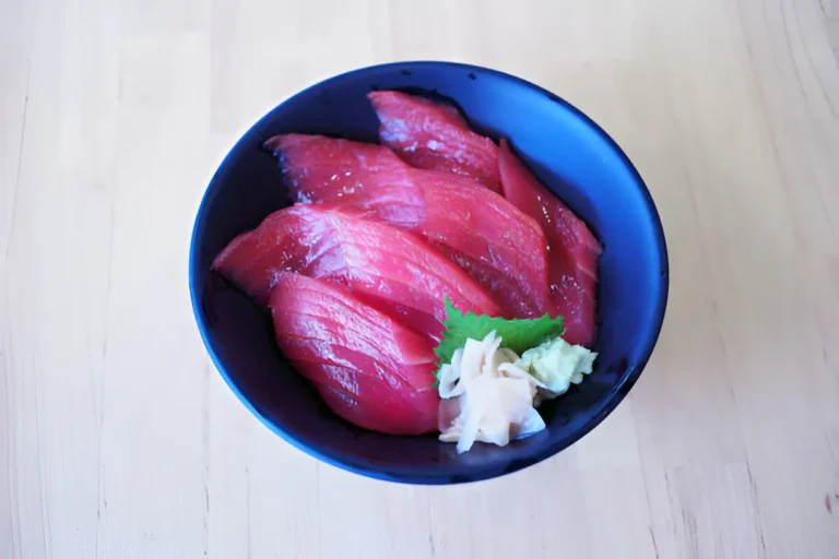 Yellowtail tuna fillet cooked with herbs and lemon, served on a plate.